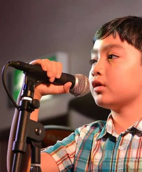 A young student singing joyfully in a lesson at Morningside School of Music in Edinburgh, showing the confidence music builds